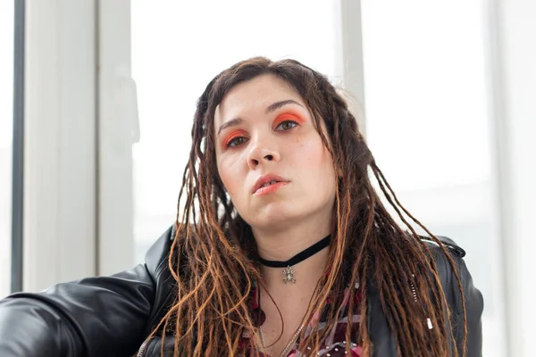 Dreadlocks, cabeleireiro e conceito de estilo - Uma menina elegante com dreadlocks e em jaqueta de couro e maquiagem elegante — Fotografia de Stock