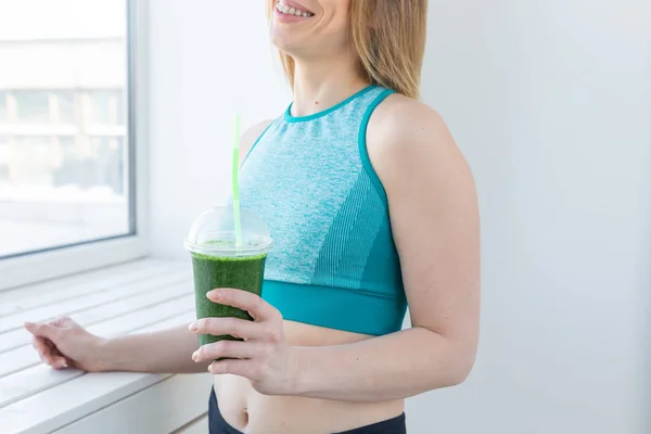 Concetto sano, fitness e disintossicazione - primo piano di giovane donna in abbigliamento sportivo con frullato verde sorridente all'interno — Foto Stock