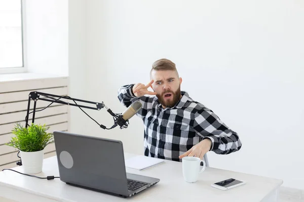 Anfitrión de radio, streamer y blogger concepto - Hombre guapo trabajando como locutor de radio en la estación de radio sentado frente al micrófono — Foto de Stock