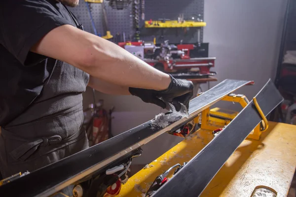 Werk-en reparatie concept-een Mans handen repareren van de ski door het wrijven van een paraffine — Stockfoto