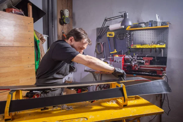 Un homme réparateur en atelier service de ski réparation du ski — Photo