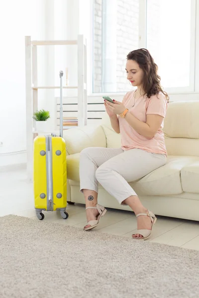 Concepto de viaje, viaje y vacaciones: la mujer con una maleta amarilla está esperando el taxi — Foto de Stock