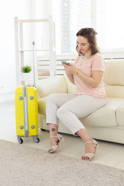 Concepto de viaje, viaje y vacaciones: la mujer con una maleta amarilla está esperando el taxi — Foto de Stock