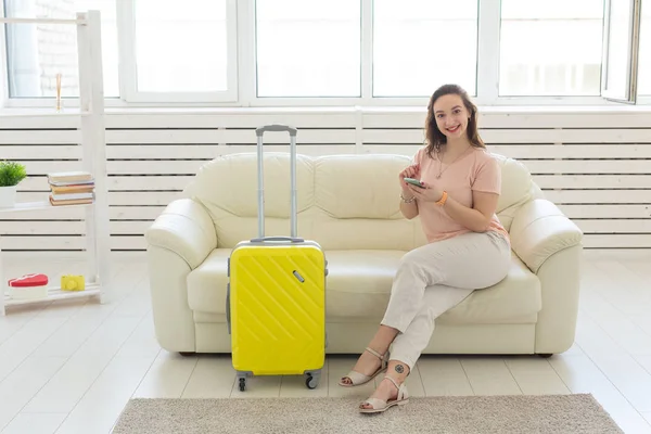 Concepto de viaje, viaje y vacaciones: la mujer con una maleta amarilla está esperando el taxi — Foto de Stock