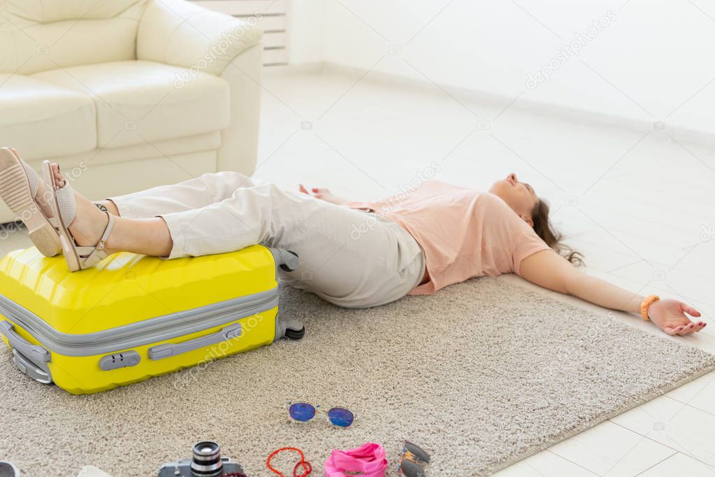 Trip, travel and holidays concept - woman is tired of collecting things for the trip