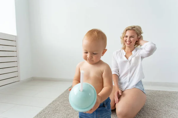 Koncepcja rodziny i rodzicielstwa-cute baby bawią się z matką na beżowy dywan — Zdjęcie stockowe