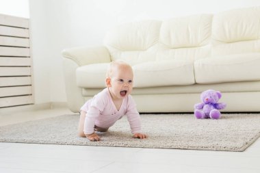 güzel gülümseyen bebek ilk kez sürünerek.