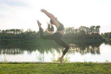Uyum ve sağlıklı yaşam tarzı kavramı - Spor giyim yoga yoga genç ince kadın açık havada yoga.