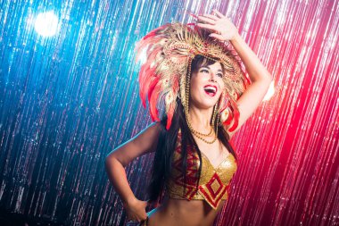 Karnaval, oryantal dans ve tatil konsepti - Altın kostüm giyen ve gülümseyen güzel kadın samba dansçısı