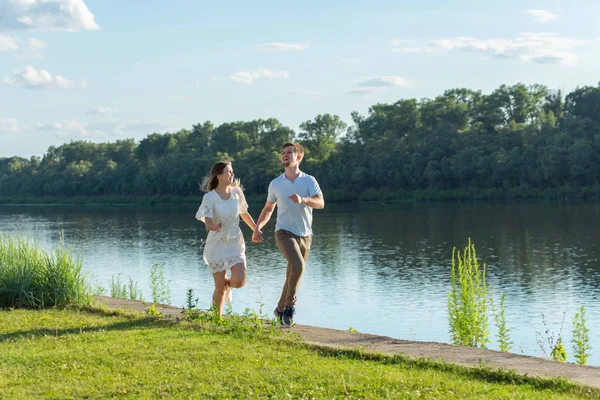 Yaz doğa, ilişki ve aşk kavramı insanlar - mutlu çift göl yakınında çalışan — Stok fotoğraf