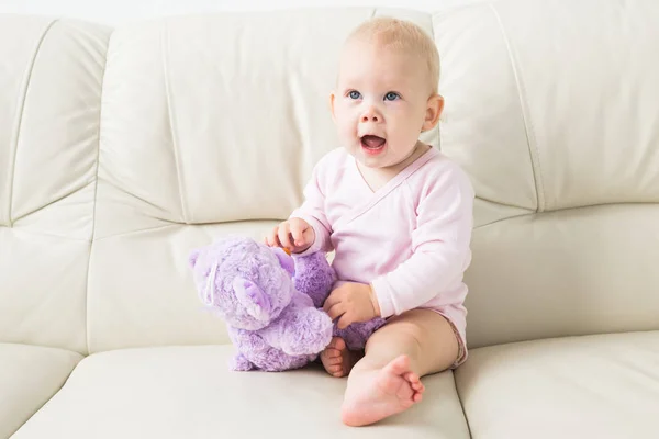 Dzieciństwo, niemowlęctwo i ludzie koncepcja-Happy Little Baby Girl siedzi na kanapie w domu — Zdjęcie stockowe