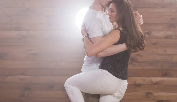 Dança social, bachata, kizomba, tango, salsa, conceito de pessoas - Close-up de jovem casal dançando sobre fundo de madeira com espaço de cópia — Fotografia de Stock