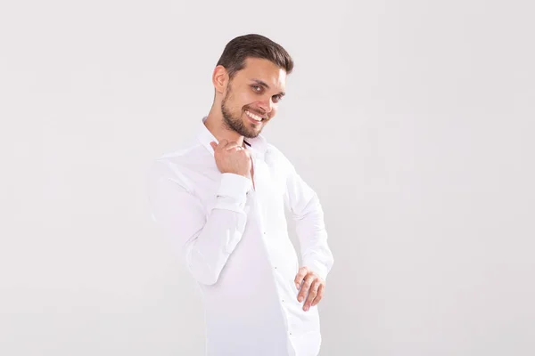 Retrato de joven feliz guapo en camisa casual de pie sobre fondo blanco con copyspace — Foto de Stock