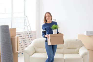 Büyüleyici genç bekar kadın onu gri lop kulaklı İskoç kedi yanında yeni bir dairede ayakta iken hareket ederken şeyler ile bir kutu tutar. Hareketli ve housewarming kavramı.