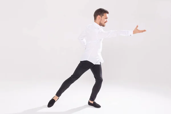 Schöner junger Mann tanzt auf weißem Hintergrund — Stockfoto