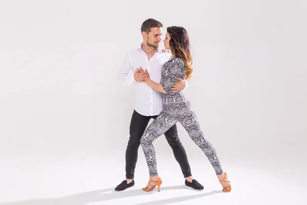 Social dance, bachata, kizomba, zouk, tango - L'uomo abbraccia la donna mentre balla su sfondo bianco con spazio per copiare — Foto Stock