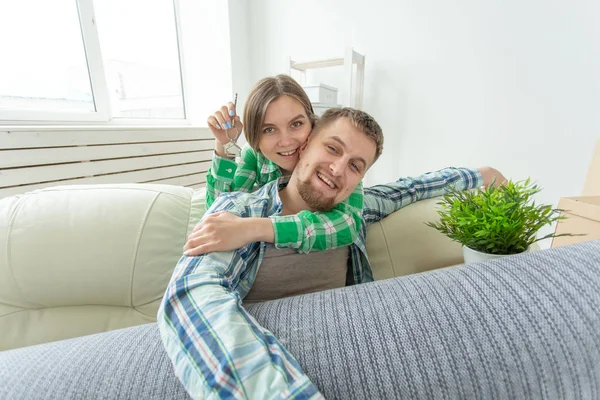 거실에 서있는 동안 새 아파트의 열쇠를 들고있는 젊은 재미 긍정적 인 부부. 집안일 및 가족 모기지 개념. — 스톡 사진