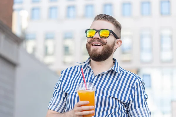 Retrato de vista inferior de un hombre hipster joven con estilo en vasos de espejo con jugo en el fondo del centro de negocios. Vacaciones urbanas en el concepto de fin de semana . — Foto de Stock