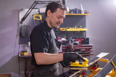 Serviste kayağı tamir eden bir adam.