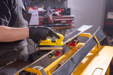 Onarım, servis ve insan kavramı - bir parafin sürtünme tarafından kayak tamir bir adam