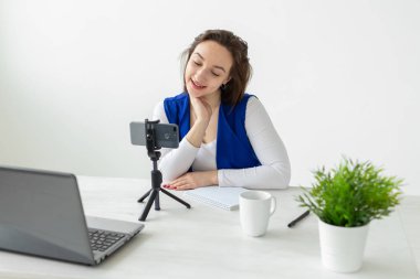 Bloglama ve vlog kavramı - genç kadın blogger kamera konuşuyor