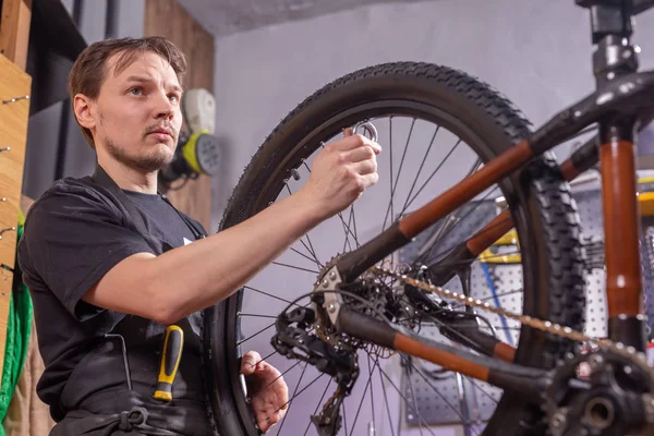 Service, reparatie, fiets en mensen concept-monteur repareren van een mountainbike in een workshop — Stockfoto