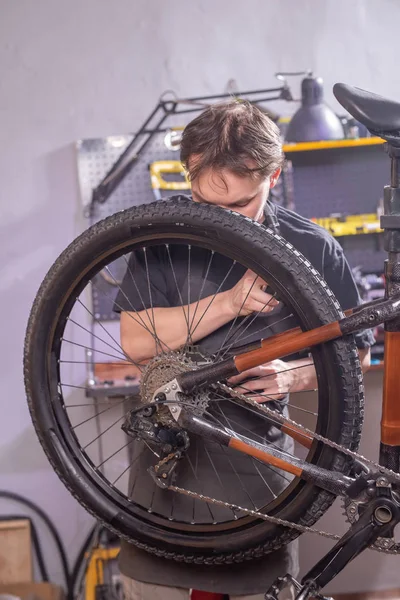 Service, reparatie, fiets en mensen concept-monteur repareren van een mountainbike in een workshop — Stockfoto