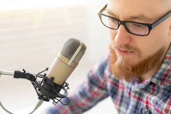 Radio, DJ, blogging y concepto de personas - Primer plano del hombre sentado frente al micrófono, host en la radio — Foto de Stock