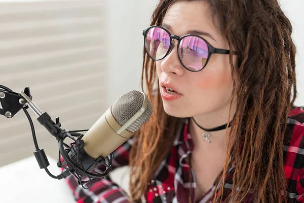 Broadcast, music, dj and people concept - woman with dreadlocks and glasses working at the radio — Stock Photo, Image