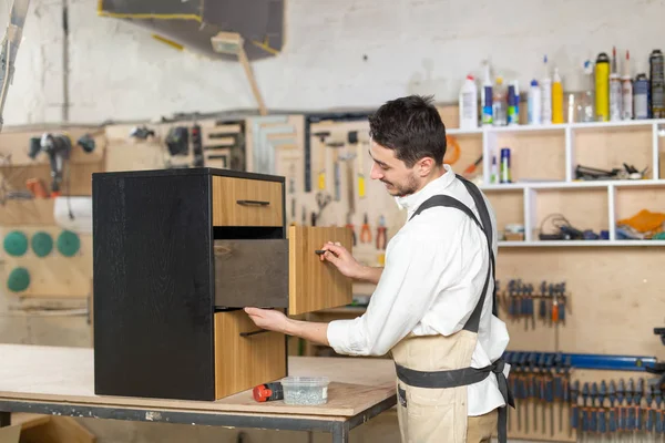 Meubelfabriek, kleine bedrijven en People concept-Young Man werkzaam bij de meubelproductie — Stockfoto