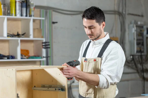 Meubelfabriek, kleine bedrijven en People concept-Young Worker werkt in een fabriek voor de productie van meubelen — Stockfoto