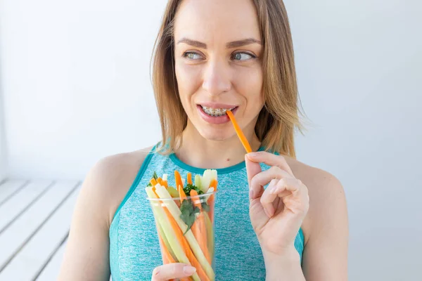 Mode de vie sain femme manger des légumes souriant heureux à l'intérieur. Jeune femme mangeant des aliments sains close-up . — Photo