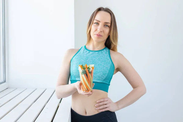 Concepto de dieta - Mujer estilo de vida saludable sosteniendo verduras en el interior. Mujer joven comiendo alimentos saludables . —  Fotos de Stock