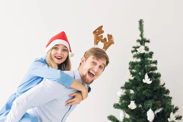 Vacanze invernali e concetto di famiglia - Felice giovane coppia vicino all'albero di Natale a casa — Foto Stock