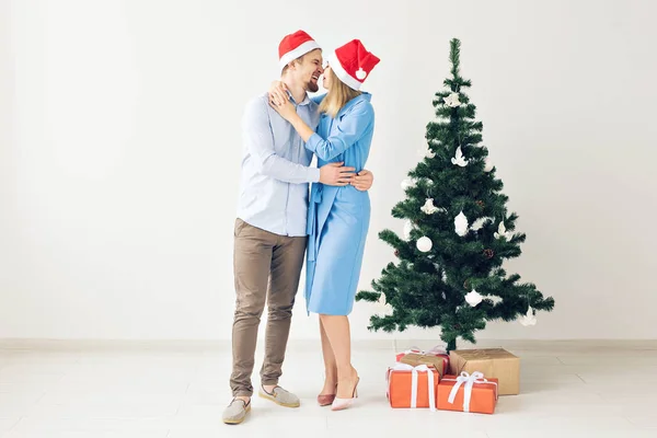 Téli ünnepek és a családi koncepció-boldog fiatal pár közelében karácsonyfa otthon — Stock Fotó
