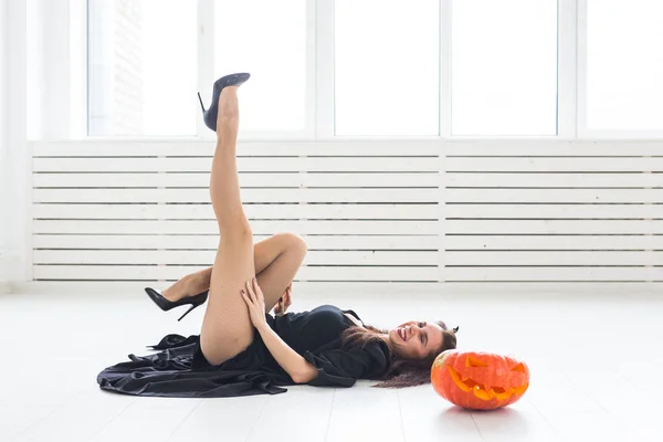 Halloween en maskerade concept - mooie jonge vrouw poseren met pompoen Jack-o-lantaarn — Stockfoto