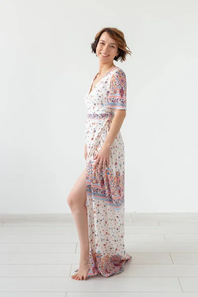 服のデザイナーと人々のコンセプト - 白い背景の上に床の長さのドレスの女性 — ストック写真