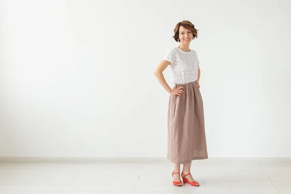Люди, мода и стиль концепция - молодая женщина позирует в одежде в студии на белом фоне . — стоковое фото