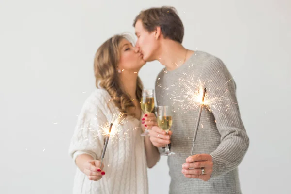 新年、休日、日付、バレンタインデーのコンセプト - 白い背景の上にスパークラーライトとシャンパンのグラスを保持する愛するカップル — ストック写真