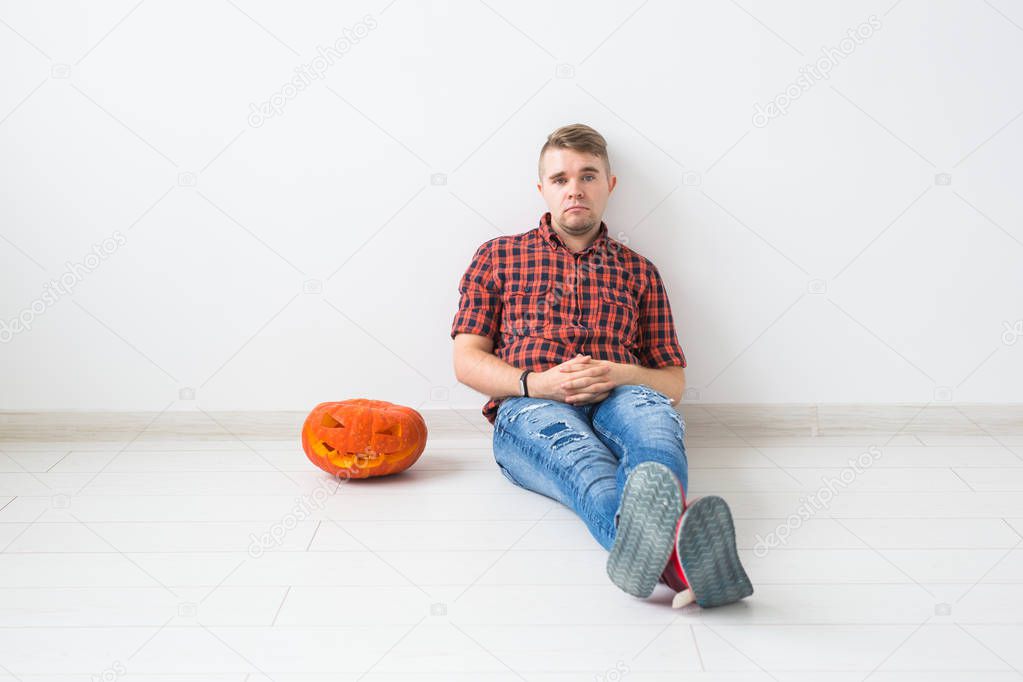 Halloween and masquerade concept - Handsome man posing with Pumpkin Jack lantern
