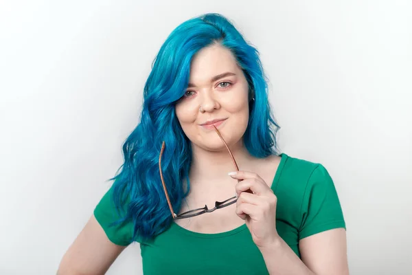 Juventude, conceito elegante e moda - Jovem mulher bonita com cabelo azul e óculos está sorrindo sobre fundo branco — Fotografia de Stock