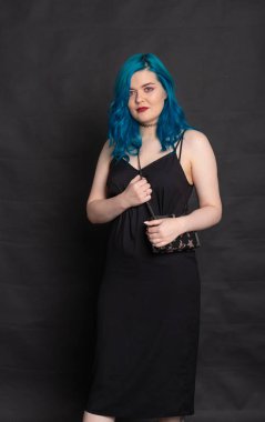 İnsanlar, moda ve saç konsepti - siyah arka plan üzerinde mavi saçlı siyah elbiseli genç kadın portresi