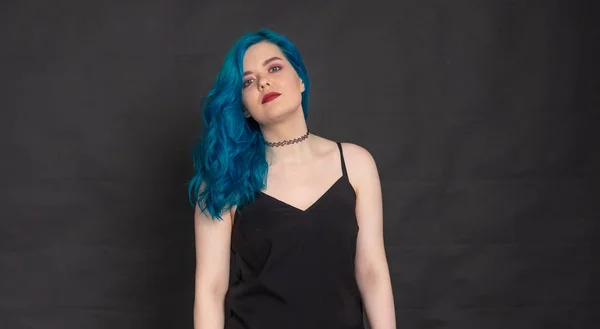 Pessoas e conceito de moda - Mulher vestida de vestido preto e cabelo azul posando sobre fundo preto com espaço de cópia — Fotografia de Stock