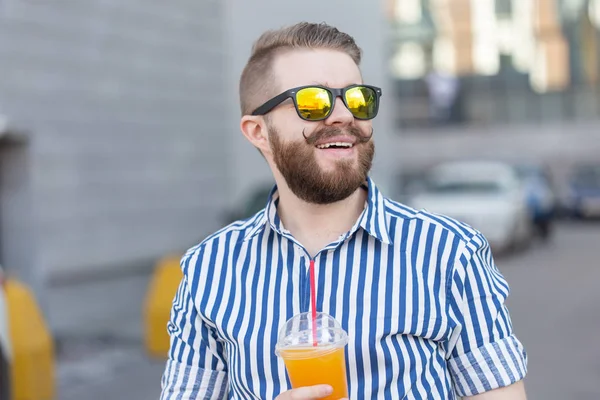 Retrato de vista inferior de un hombre hipster joven con estilo en vasos de espejo con jugo en el fondo del centro de negocios. Vacaciones urbanas en el concepto de fin de semana . — Foto de Stock