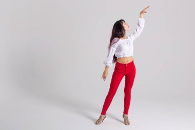 Latin dansı, striptiz dansı, çağdaş ve bachata bayan konsepti - doğaçlama dans eden ve uzun saçlarını beyaz arka planda gezdiren kadın