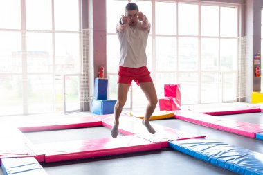 Eğlence, spor oyunları ve ilgi alanları - Komik genç adam sinek parkta trampolining