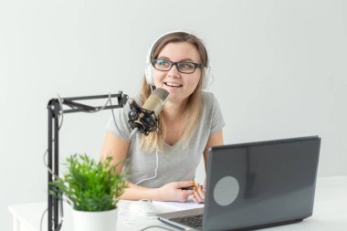 Radyo, dj, blogger ve insan kavramı - genç kadın sunucu radyo stüdyosunda çalışan ve mikrofon üzerinde konuşurken