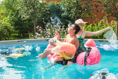 Genç adam ve kız çevre kirlenirken eğleniyor, sorun plastik geri dönüşüm ve çöp bertaraf kavramı