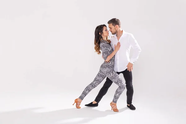 社会的なラテンダンスバチャータ、メレンゲ、サルサを踊る若いカップル。コピースペースを持つ白い背景に2つの優雅なポーズ — ストック写真