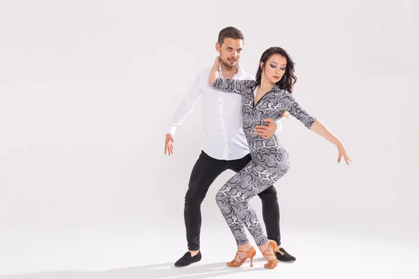 Dança social, bachata, kizomba, zouk, conceito de tango - Homem abraça mulher enquanto dança sobre fundo branco com espaço de cópia — Fotografia de Stock